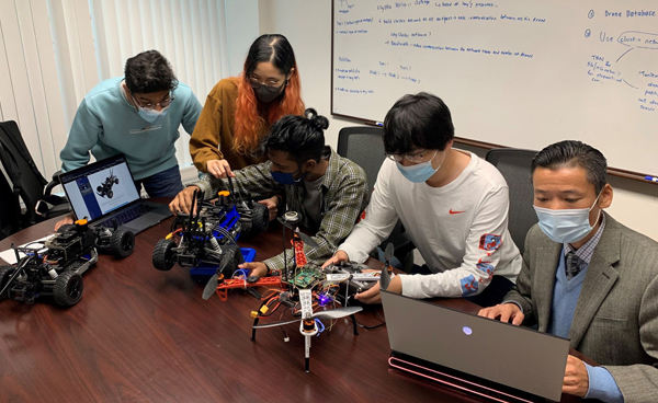 Dr. Liang Cheng working with members of the Learning and Optimization on Networks and Graphs Laboratory