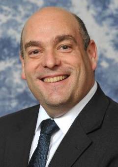 smiling bald man in blue suit and tie