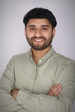 Yukesh posing in front of white background.