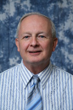 smiling man in blue striped shirt and tie