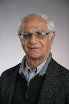 smiling man in brown jacket and blue shirt