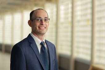 Smiling man with glasses in blue suit and tie