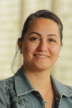 smiling brown haired woman in jean jacket