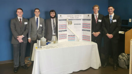 team members standing next to project display board