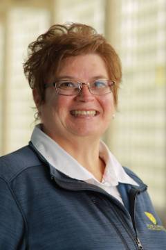 smiling woman with glasses in blue University of Toledo jacket