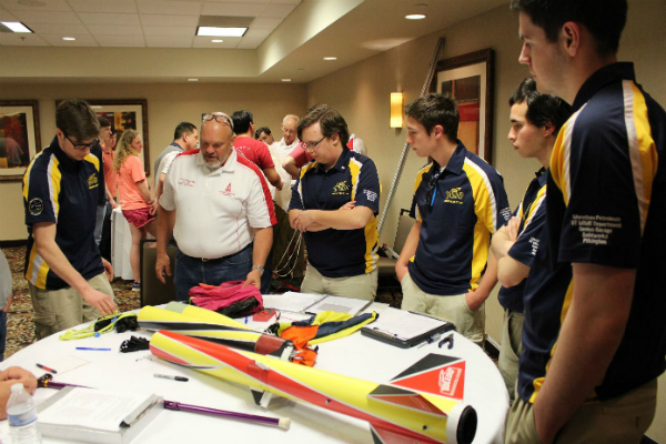 5 members of the rocketry team with rocket on display