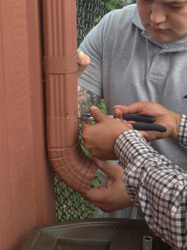 preparing cut downspout for barrel