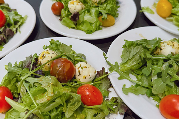 salad plates with arugula, tomatoes, mozzarella, and italian dressing