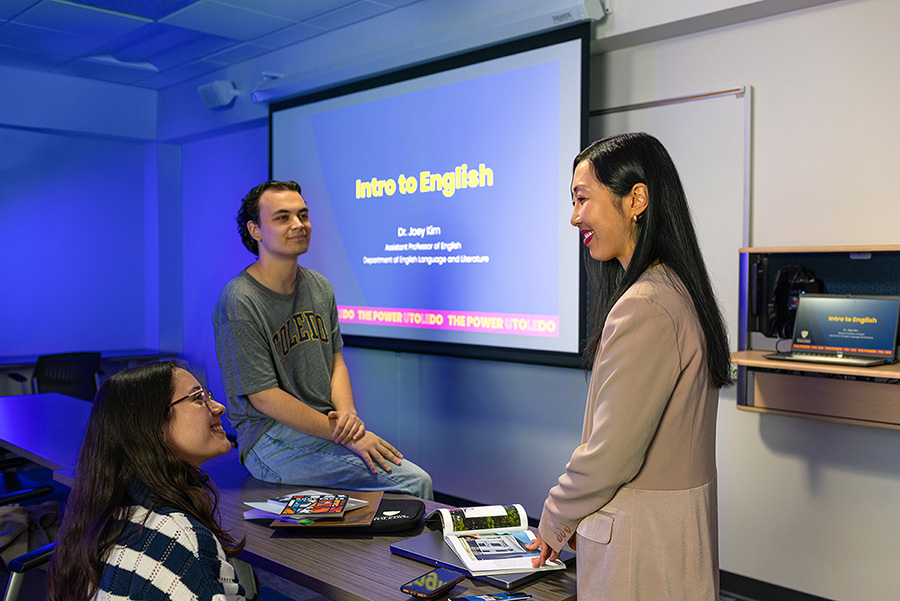 three people sitting in a room talking with a projected screen