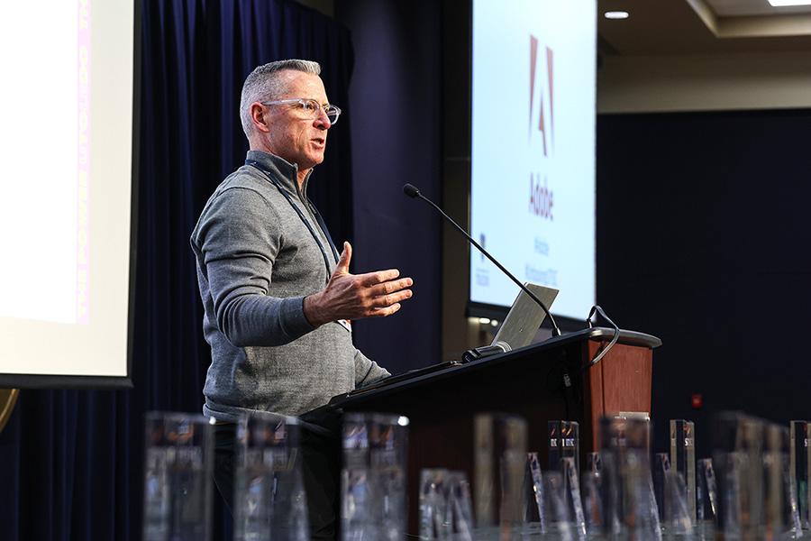 man speaking at a podium in a large auditorium