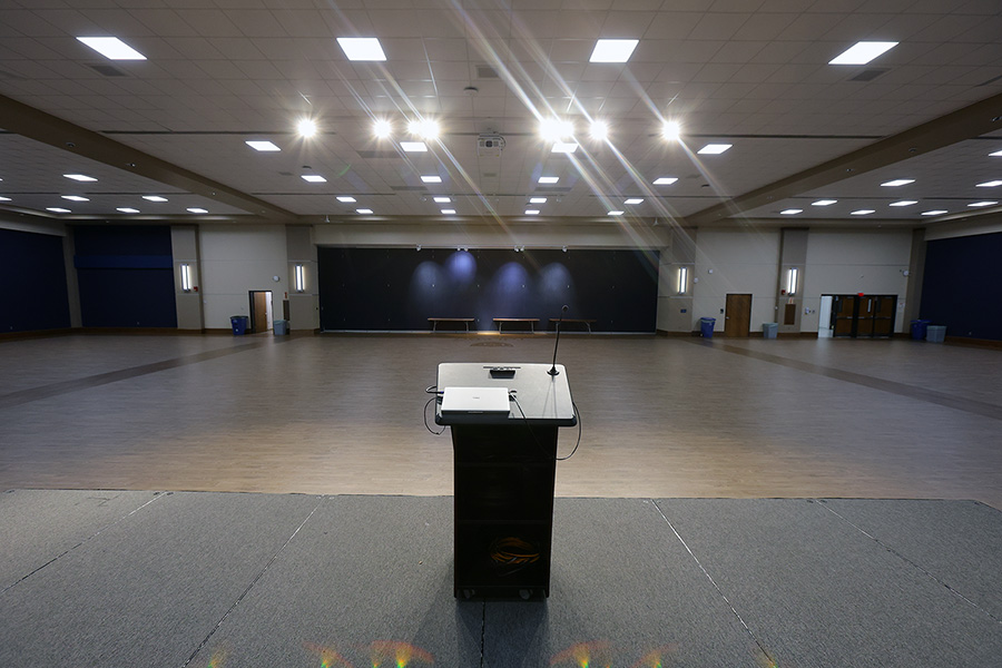 view from stage being podium of an empty auditorium with wood floors and spotlights