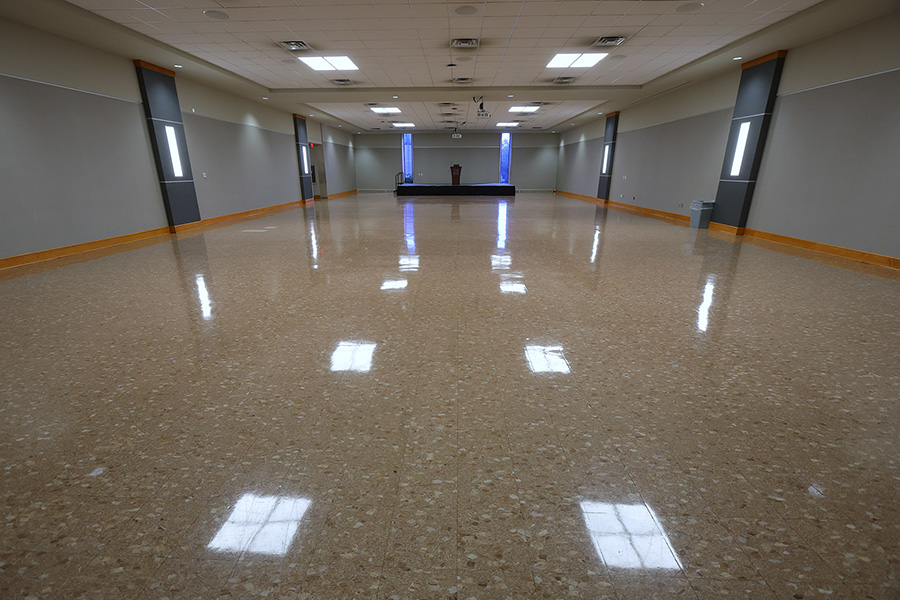 empty large room arranged with a small stage and a podium