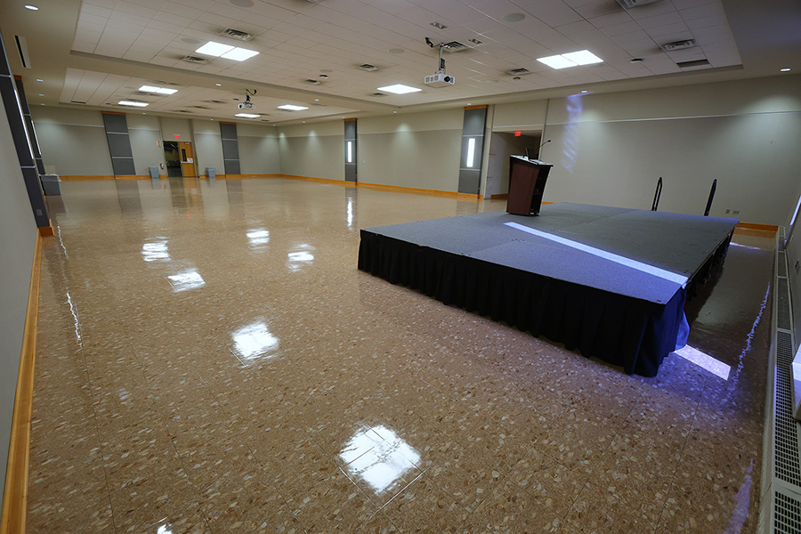 empty large room arranged with a small stage and a podium