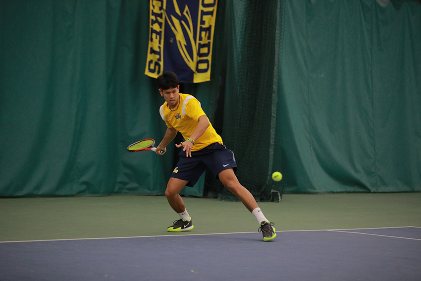 UToledo men's tennis player Pawit Sornlaksup winding up to hit a tennis ball on the court