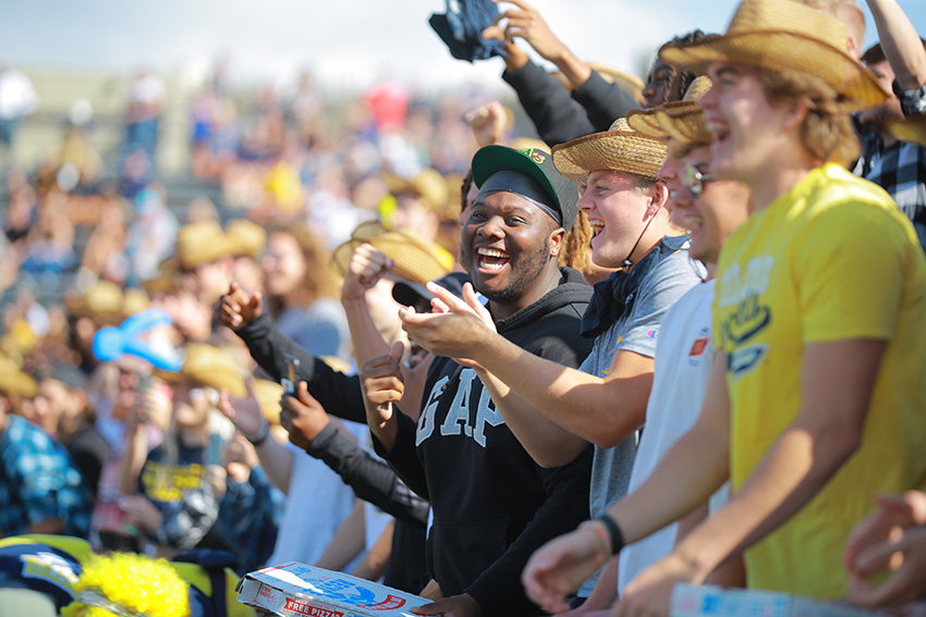 Fans of the UToledo Rockets cheering for them at an outdoor game