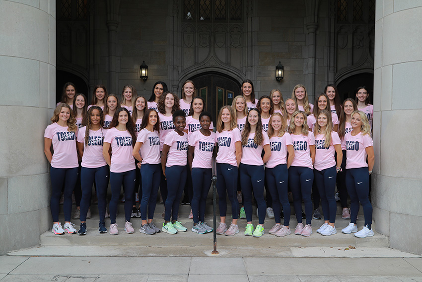 The UToledo women's cross country team posing for a group photo, all wearing UToledo shirts