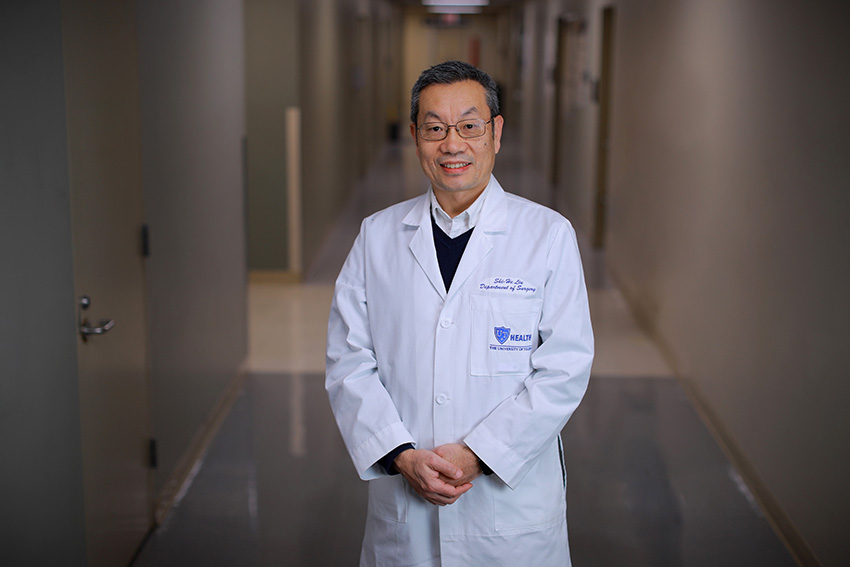 Shi-He Liu, M.D., standing in a hallway