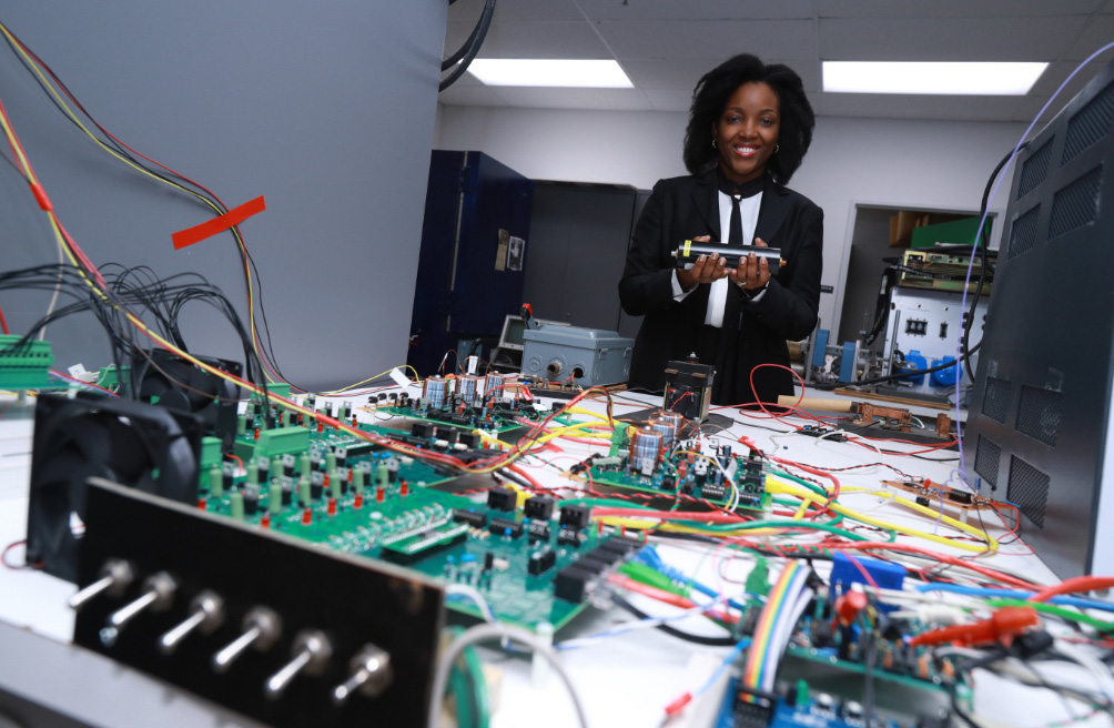 Dr. Ngalula Mubenga with various electronics