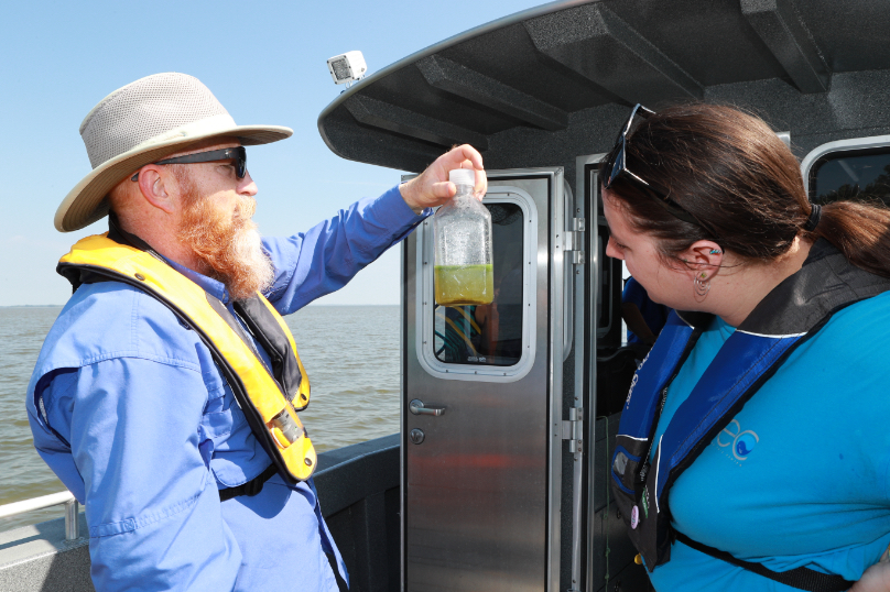 Dr. Tom Bridgeman studing a water sample on the resarch vessel