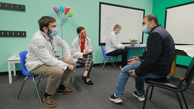 Medical students attentively listening to a patient in a CommunityCare Clinic