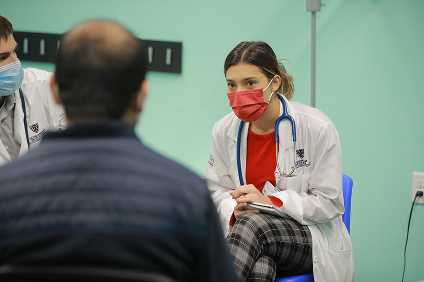 A medical student attentively listening to a patient in a CommunityCare Clinic