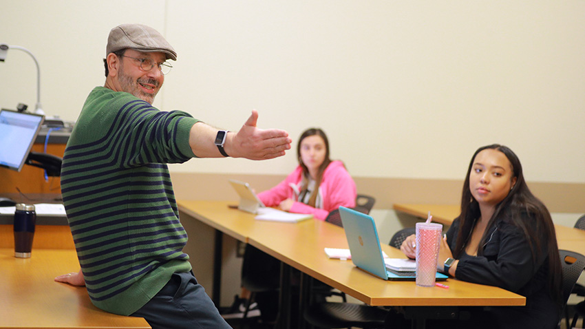 A UToledo professor enthusiastically teaching students in a classroom.