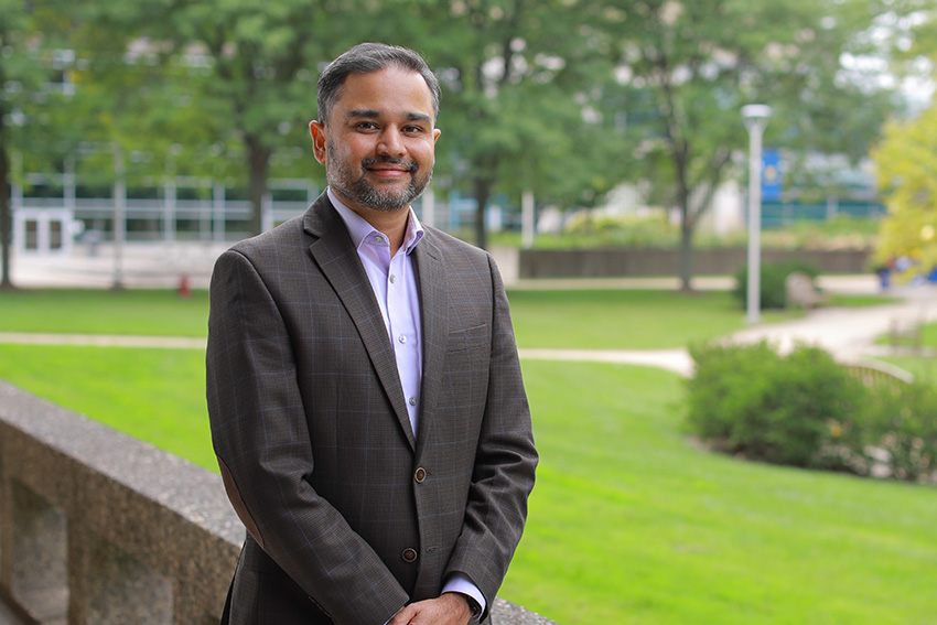 Varun Vaidya, Ph.D., standing outdoors on UToledo's campus, wearing a business suit