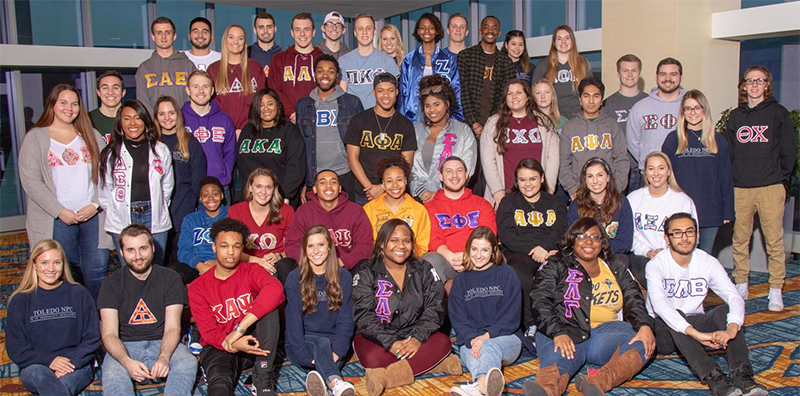 Fraternity and Sorority students chatting on a bench