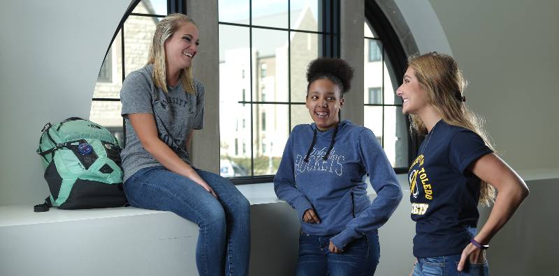 student chatting near a window