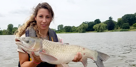 Kaitlen Lang holding a carp on a boat in Lake Erie