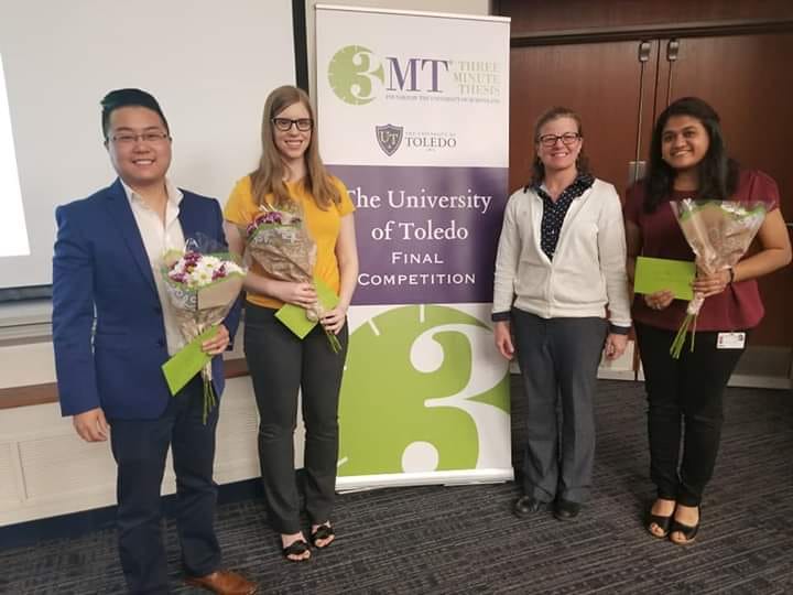 2019 Three Minute Winners and associate dean posed in front of banner. From L to R: Robin Su, Rachel Golonka, Dr. Cyndee Gruden, Gayatri Subramanian