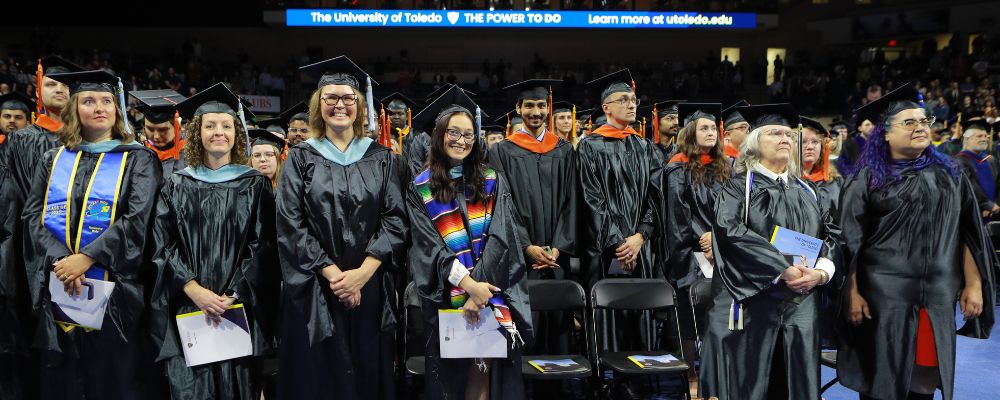 Master degree candidates standing side by side at commencement