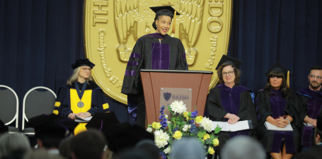 Graduate speaking on stage at College of Law Commencement