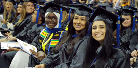 College of Business master's degree graduates seated and smiling during commencement