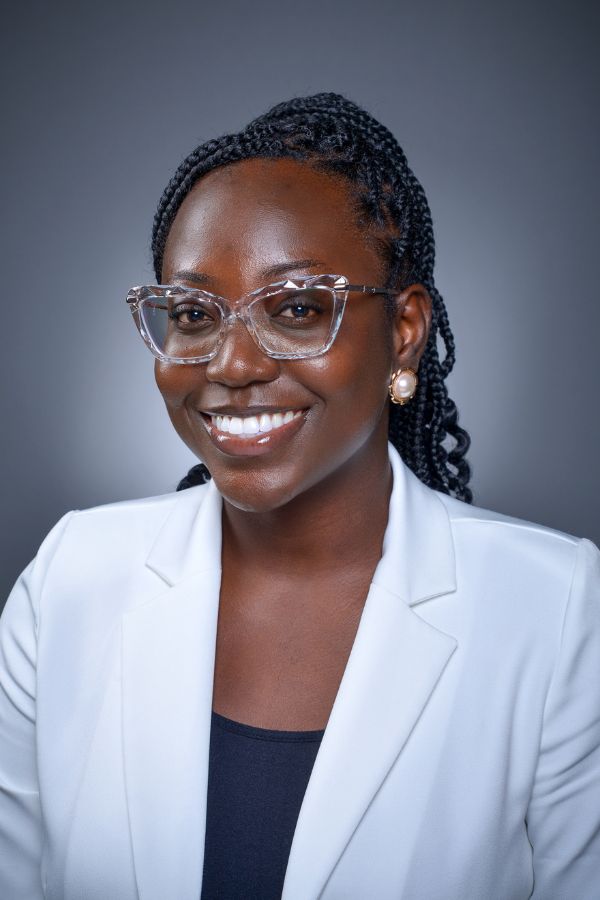 Dorcaslove Quartey Headshot of Dorcaslove Quartey. Woman in glasses and white blazer smiling.