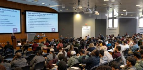 Students seated in lecture hall listening to a presentation.