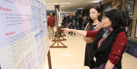 Student presenting research poster indoors