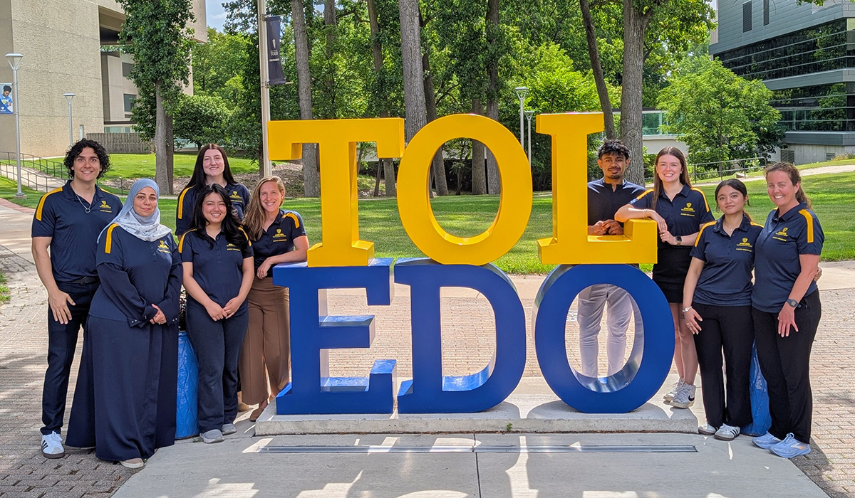 college of health and human services students standing around the Toledo sign on the health science campus