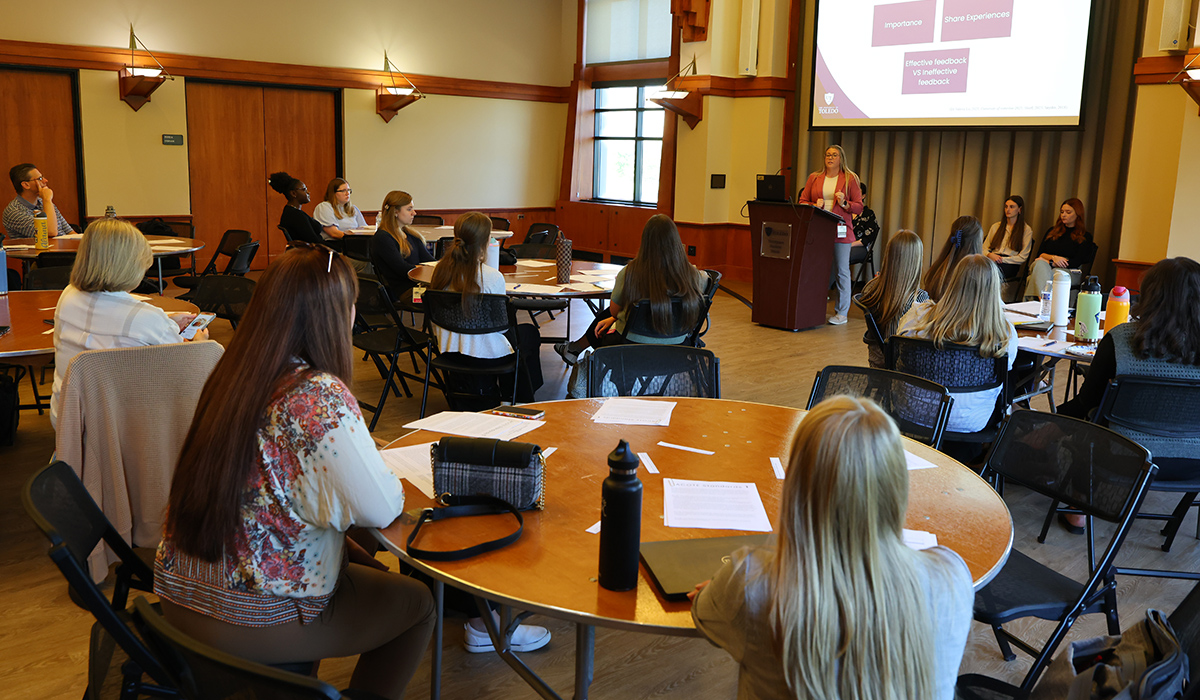 Occupational Therapy Doctorate students at the fall symposium sitting at tables listing to a speaker give a presentation