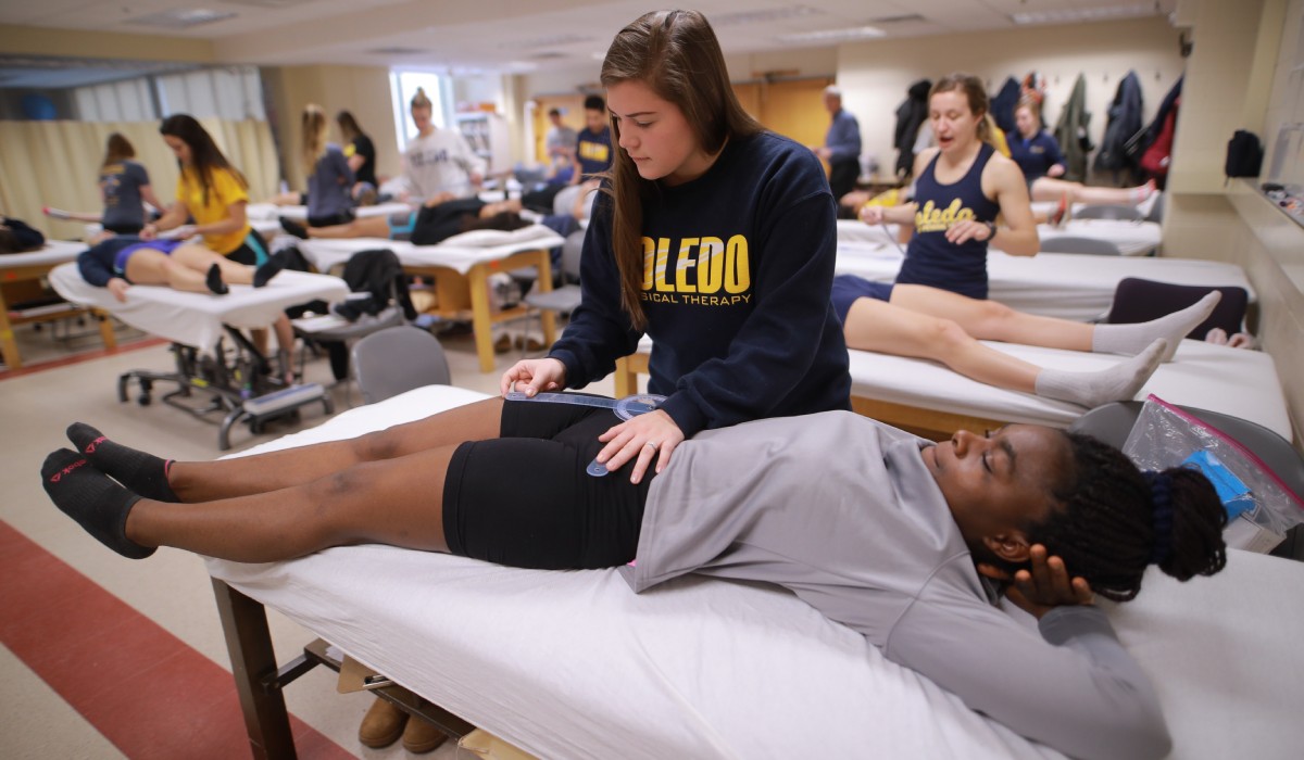 students practice clinical physical therapy movements in classroom