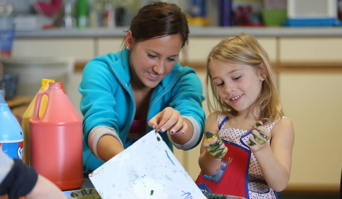 teacher and student painting in a classroom