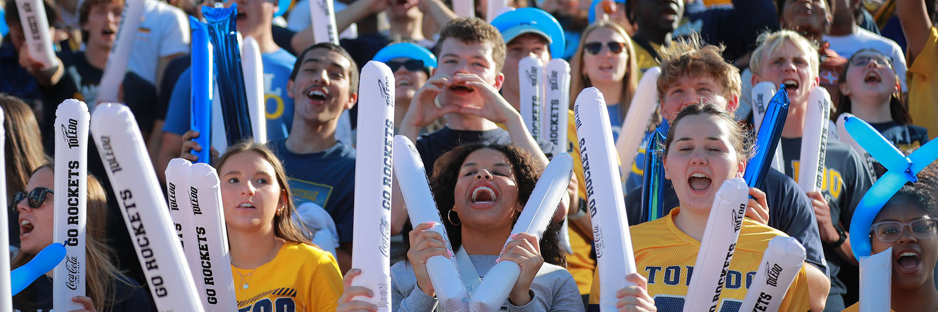 students cheering in the crowd at the homecoming football game