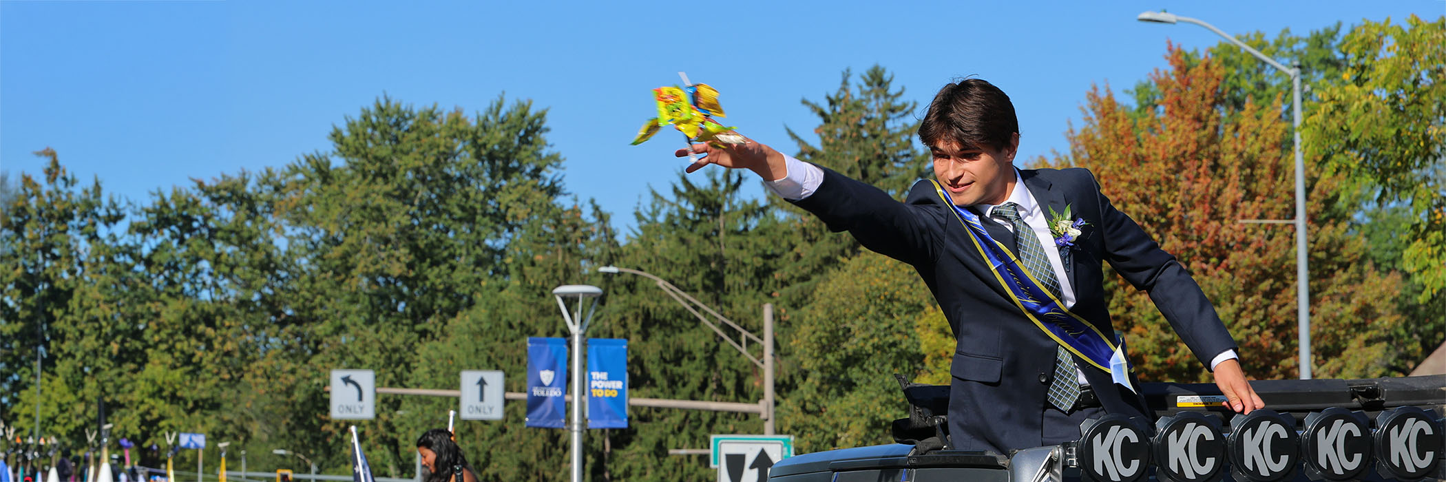 member of homecoming court throwing candy out of a jeep during parade