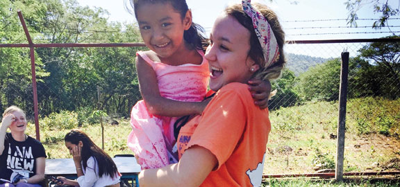 student holding little girl