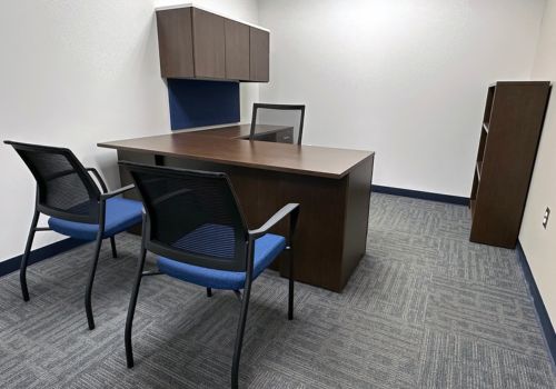Empty office with wooden furniture, and black and blue chairs