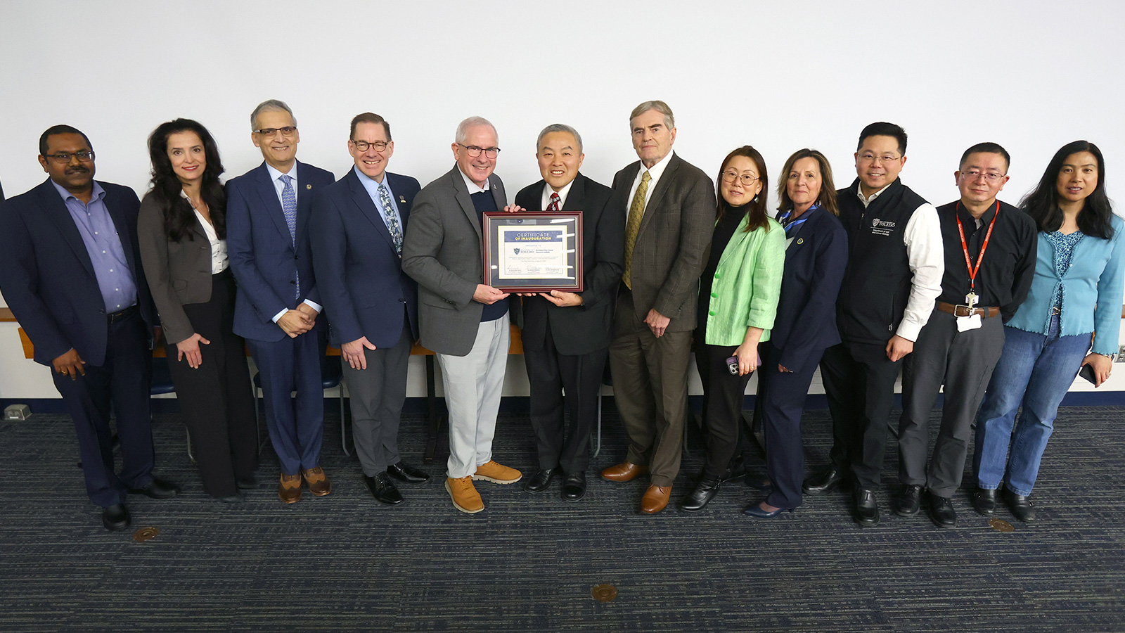 University administrators, faculty and institute members gather for a group photo holding a certificate recognizing the inauguration of the Northwest Ohio Cancer Research Institute at The University of Toledo.
