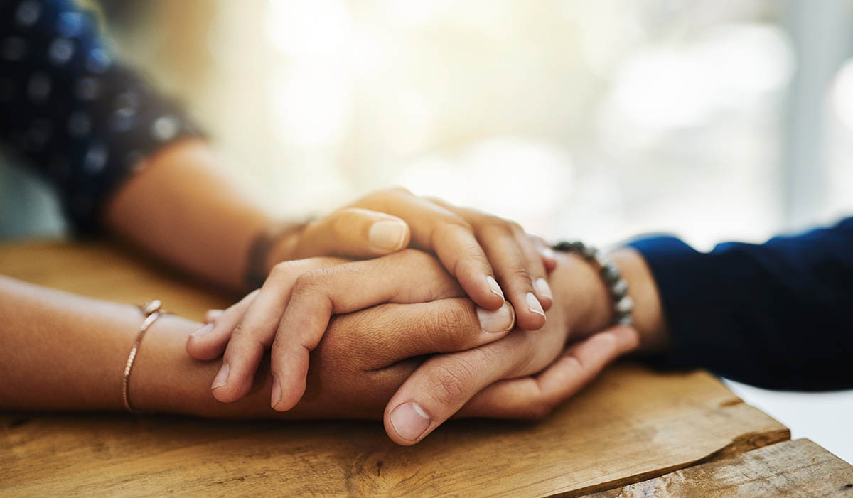 two people holding hands, comforting each other