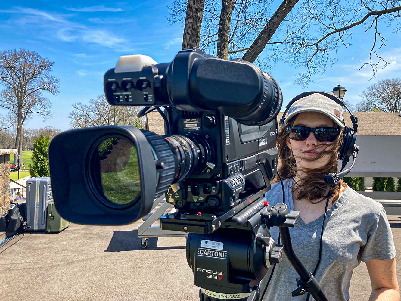 student behind a camera shooting footage