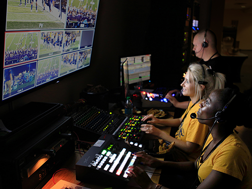 students in comm 3260 class working behind the scene in video booth