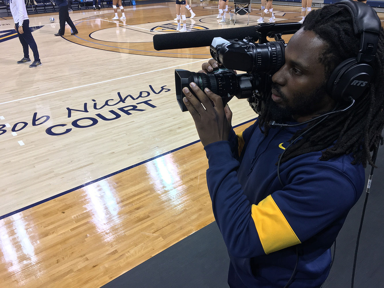 student in class on court filming basketball game